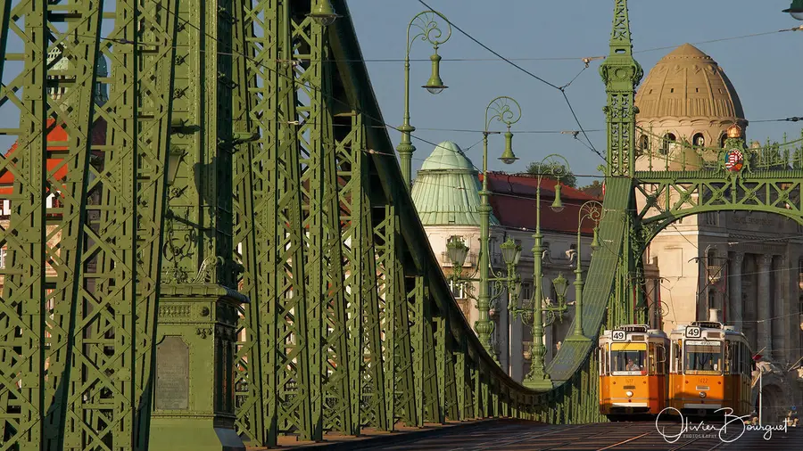 Un pont métallique vert et un tramway jaune, en Hongrie